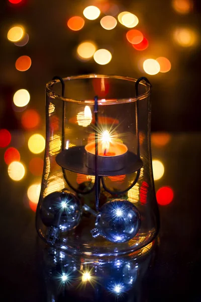 カラフルなクリスマスライトの前でガラスキャンドルホルダーのクローズアップショット — ストック写真