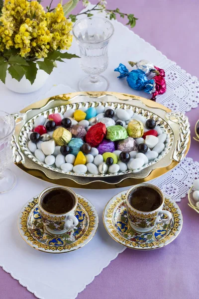 传统的宗教节日 斋月结束糖的节日 概念形象与两个土耳其咖啡和糖果 巧克力 使用时尚的金属托盘 手工制作的花边和面料桌布 图库图片