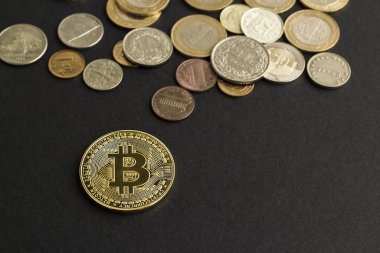 Bitcoin 'in altın fiziksel sembolü ve siyah arkaplanda diğer paralar 