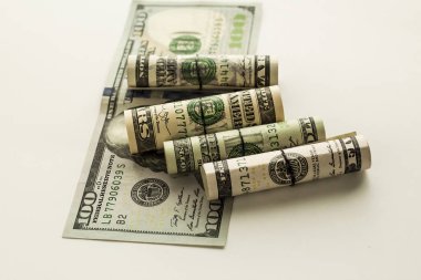 close-up shot of rolled dollar bills on white