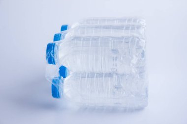close-up shot of plastic bottles of water in transparent wrap on white surface
