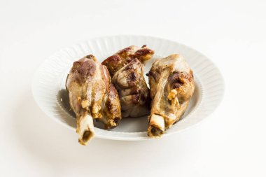 İki bıçak, beyaz tabakta kemikli et, ana yemekten önce tavada ızgara. Kurban ziyafeti konsepti.