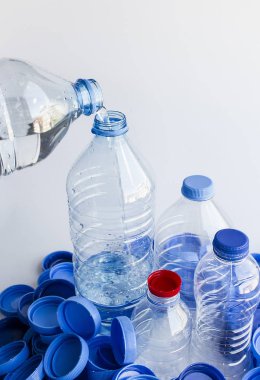 Doğal kaynak suyu, diğerlerinin yanına şişe kapaklarının üzerine dökülüyor.