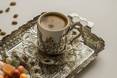 Metal tepside geleneksel Türk kahvesi ve lezzetli jöleli şekerlerden yakın çekim.
