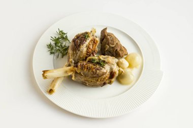 Geleneksel İslami Kurban yemeği kuzu incik ile yapılır. Taze kekik, soğan ve sarımsak ile servis edilir..