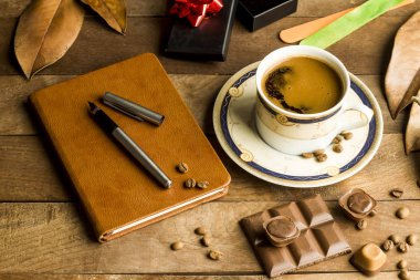 Tarçın renginde Babalar Günü konsepti, deri kaplı defter, stilografik kalem, çikolatalı kahvenin yanında.