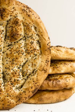 Lezzetli taze pide ekmeğinin beyaz yüzeyde üst üste yığılmış yakın plan çekimi.