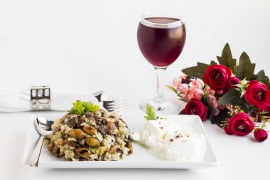 Geleneksel Türk İslami Şölen masası ağır ateşte pişirilmiş et, Kavurma ve pirinç, beyaz yüzeyde yoğurt, soğuk kiraz suyu ve kırmızı güllerle süslenmiş Pilaff.