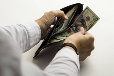 close-up shot of businessman holding wallet with dollar bills on white background