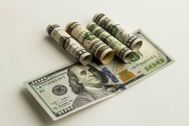 close-up shot of rolled dollar bills on white
