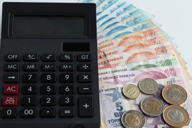 close-up shot of turkish liras and coins on white with calculator