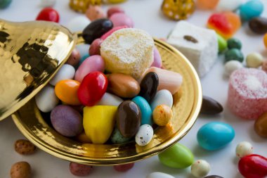 Lezzetli renkli jöleli şekerlemelerin beyaz kasede yakın plan çekimi.