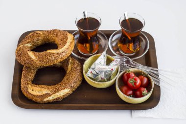 Geleneksel Türk Çayı simit, kiraz domatesleri ve ahşap tepside peynir.