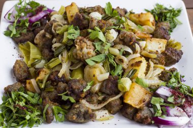 Üst görünüm: Arnavut tavada kızartılmış ciğer ve patates ve otlu 