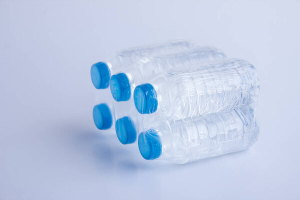 close-up shot of plastic bottles of water in transparent wrap on white surface