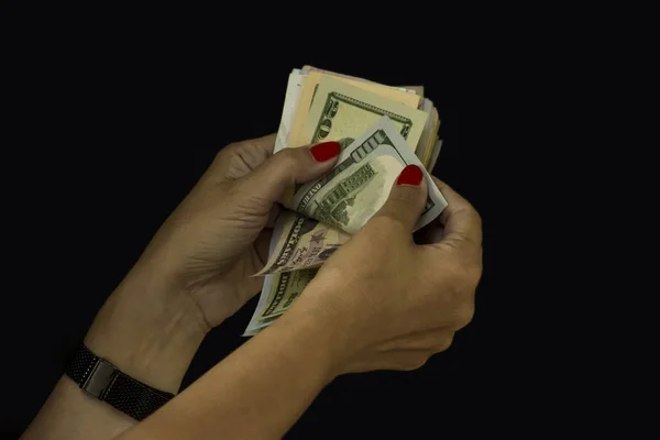 Red nails polish hands counting dollars on black background.Close up taken,isolated.