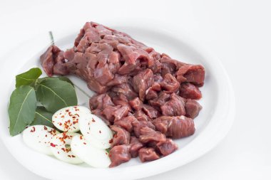 Pişmemiş, beyaz tabakta doğranmış et, soğan halkaları ve Rusya 'dan ayrılışı. Yakın çekim. Ziyafet..