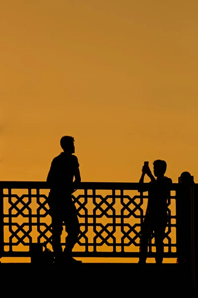 Siluetas Personas Tomando Fotos Frente Valla Atardecer — Foto de Stock