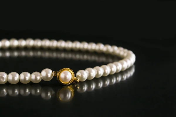 close-up shot of pearl necklace on black background