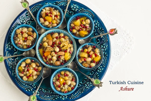 Traditional Turkish Dessert Asure or Noah's Pudding in the stylish blue color ceramic bowls and writting near,Turkish Cuisine,Ashure