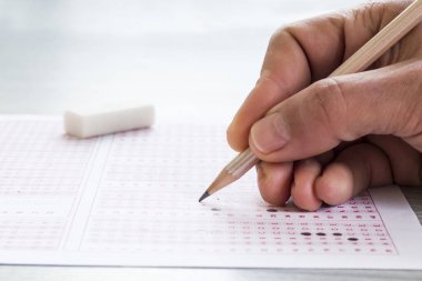 Yakın çekim, sınav kağıdını tahta kalemle doldurmak, eğitim sınavının kavramsal görüntüsüdür..