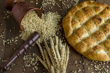 Geleneksel Türk Ramazan Ekmeği ahşap masanın üzerinde bir demet buğday ve tahıl ile 