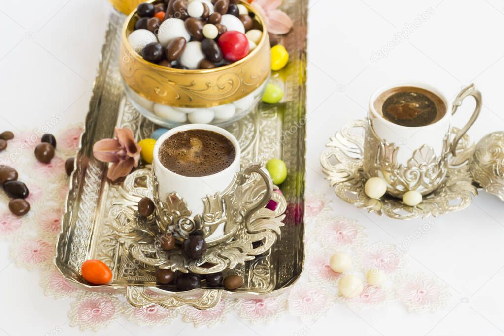 Traditional Turkish Hard Almond Candies designed on white surface with chocolate and coffee.