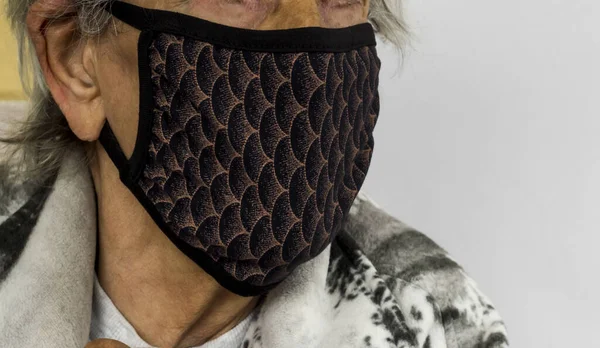 Unknown,old person is using handmade washable fabric face mask on white with copy space.
