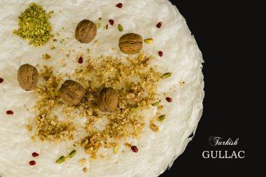Traditional Turkish Ramadan Dessert Gullac ingredients sheets walnuts and diced nuts on black background with,Gullac Turkish writing.