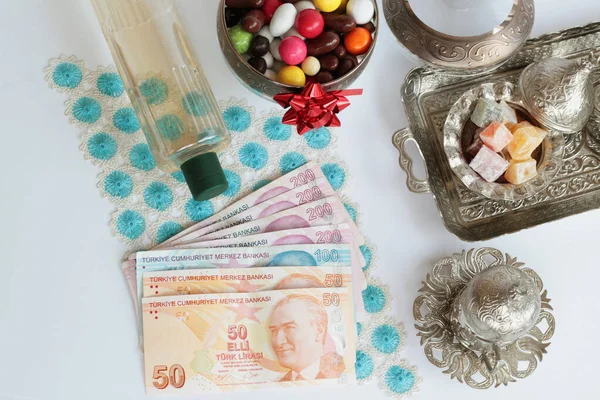 土耳其数千里拉 手工制作的花边布 配以古龙水 五颜六色的糖果和土耳其咖啡套装 土耳其退休假日奖金的概念 免版税图库图片