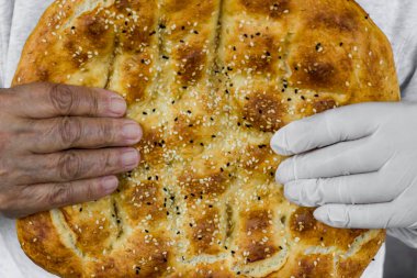 Eldivenli ve eldivensiz ramazan ekmeği tutan bilinmeyen kişi, yakınlaş. 