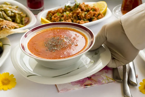 Ramazan Yemeği Masasında Geleneksel Türk Çorbası servis eden eldivenli el..