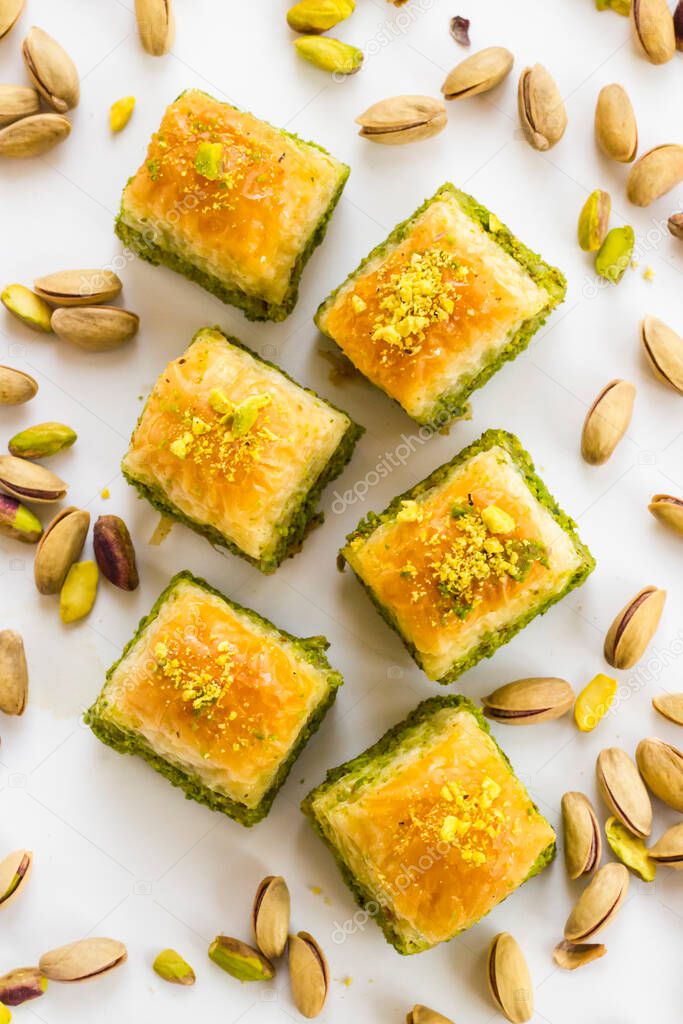 Traditional Turkish Pastry Dessert  Pistachio Baklava on white with pistachio nuts.Vertical image