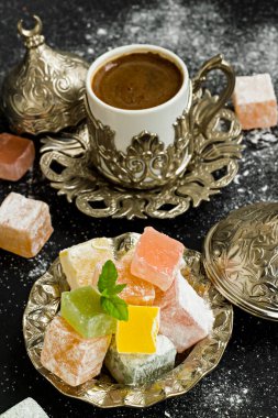 Geleneksel Türk Lokumu şık gümüş şeker kasesi ve Türk Kahvesi üzerine siyah pudra şekerli şeker. Şeker Şöleni.