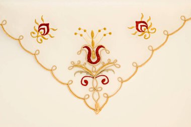 Makine işlemeli kumaş peçete, parlak arkaplanda stilize edilmiş kırmızı çiçek..