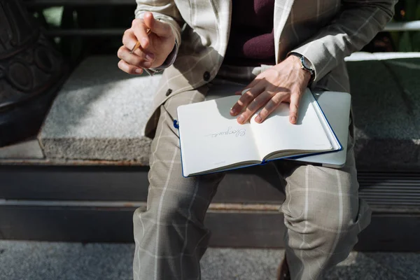 Mann schreibt auf sein Notizbuch — Stockfoto