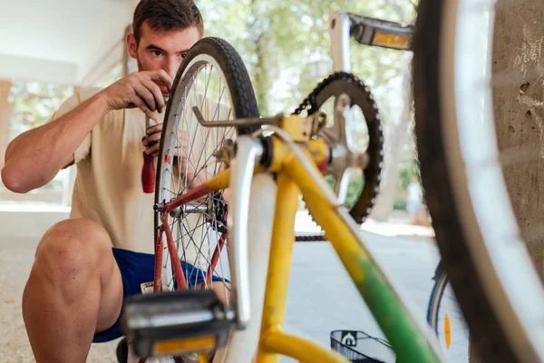 Homem verificando sua roda de bicicleta depois de ser reparado — Fotografia de Stock