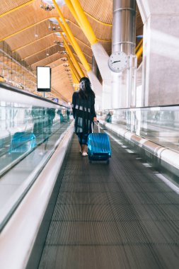Kadın bir havaalanında hızlı bir hareket geçit içinde yürüyüş