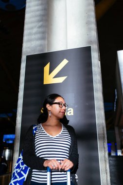 Bir sütunda havaalanında bekleyen kadın