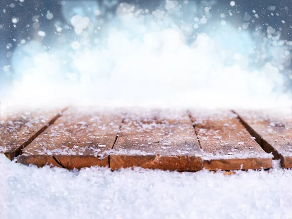 Wooden table, bench covered in snow with a Christmass, wintery a