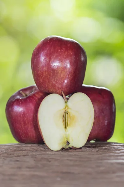 Apple on a wooden floor and has a background of nature — Stock Photo, Image