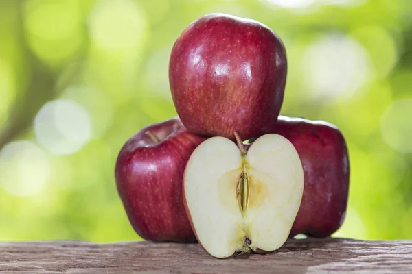 Apple on a wooden floor and has a background of nature — Stock Photo, Image