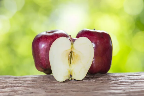 Apple on a wooden floor and has a background of nature — Stock Photo, Image