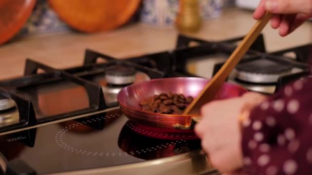 Girl stir coffee beans with a spatula in a copper skillet — Stock Video