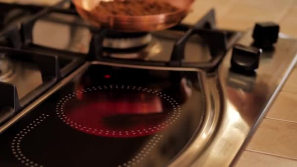 Chica pone en el plato la sartén con granos de café. Cocina estufa . — Vídeo de stock