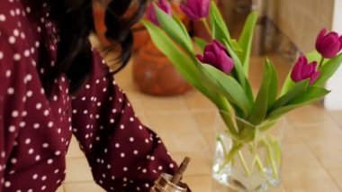 Young girl in polka dot dress fills the grinder with beans roasted coffee