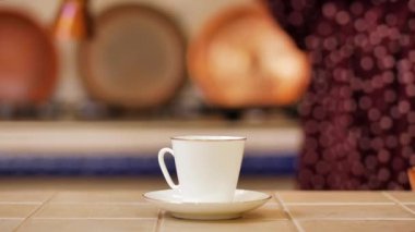 The girl pours coffee from a cezve in a white Cup