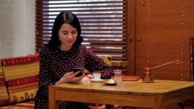 Young girl in polka dot dress drinking coffee