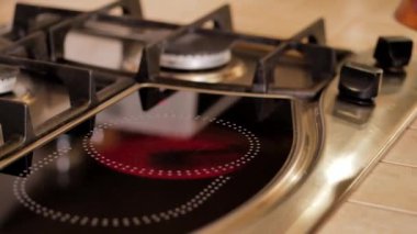 Girl puts on the plate the pan with coffee beans. Kitchen stove.
