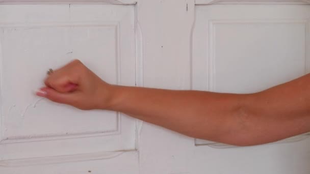 Una joven llama a la puerta con la mano — Vídeos de Stock